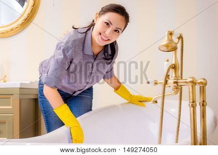Young beautiful asian woman housekeeping in the bathroom