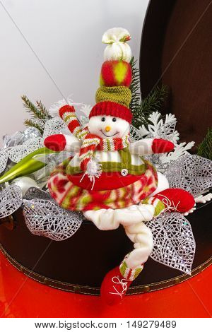 Funny snowman sits on vintage brown coffer with white christmas tree decoration copy space