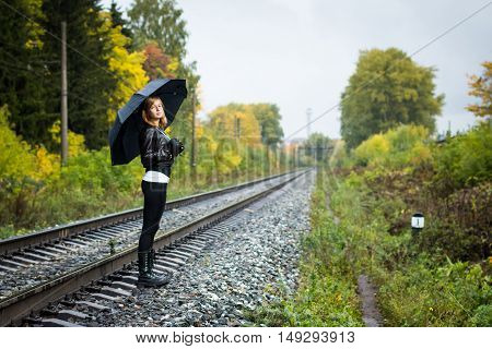 Girl, Umbrella And Rails In Autumn Day