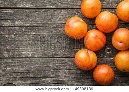 Ripe yellow plums on old wooden table. Top view.