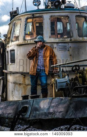Old salt man smoking on his rusted ship
