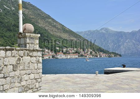 The Our Lady of the Rock island in Kotor Bay Montenegro. The island was artificially created by locals using rocks. The village of Perast can be seen in the background