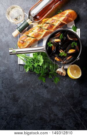 Mussels in copper pot and white wine on stone table. Top view with copy space