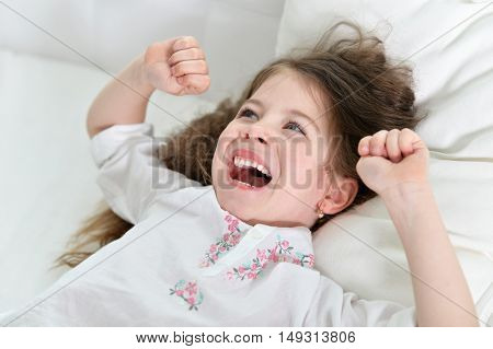 Adorable little girl awaked up in her bed