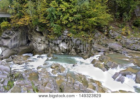 Prut river and its rapids in Carpathian mountains at rainy autumn day