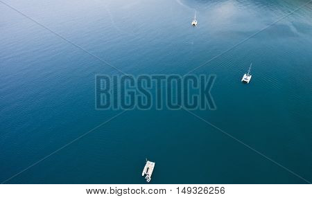 Top view aerial photo from flying drone of a riding catamarans in open sea with calm waves with copy space for your advertising text message or promotional content in summer seasona in Thailand