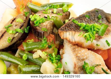 baked fish with vegetables close-up on the background
