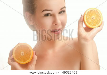 Young beautiful smiling woman holding two halves of an orange White background