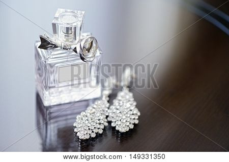 Beautiful wedding rings and perfume bottle for bride and groom. Beauty of wedding accessories indoors. Close-up bridal jewellery and perfumery. Female and male jewel. Jewelry for man and woman