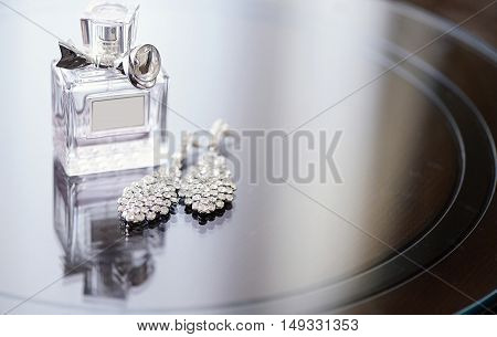 Beautiful wedding rings and perfume bottle for bride and groom. Beauty of wedding accessories indoors. Close-up bridal jewellery and perfumery. Female and male jewel. Jewelry for man and woman