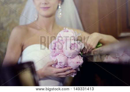 Beautiful bride is holding a wedding colorful bouquet. Beauty of colored flowers. Close-up bunch of florets. Bridal accessories. Female decoration for girl. Details for marriage and for married couple