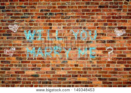 Brick wall with the text :  Wll you marry me?