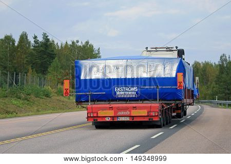 ORIVESI FINLAND - SEPTEMBER 1 2016: Rear view of a semi truck which transports an oversize load on lowboy trailer along highway in Central Finland.