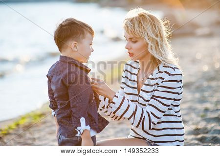Beautiful woman with a child of four years playing on the beach near the sea