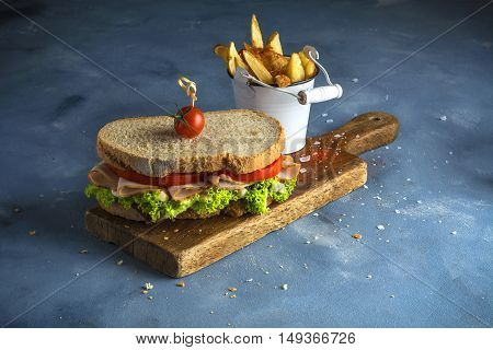 Turkey sandwich with lettuce and tomato and chips.