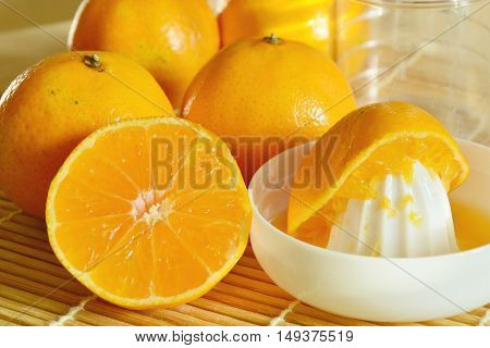 oranges with Reamer juicer on bamboo mat