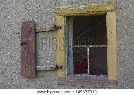 an old open broken window on wall