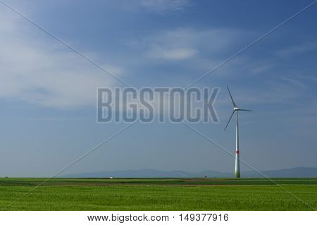 meadow with Wind power turbines generating electricity