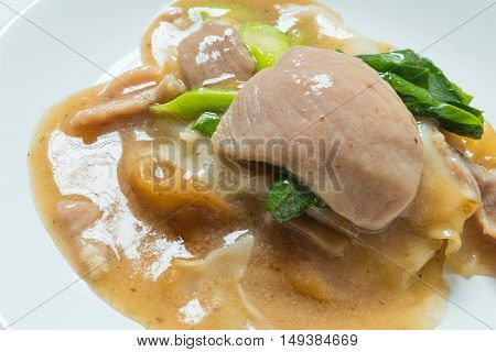 Rad Na Famous Thai Chinese style wide rice noodle dish with tasty tender pork with thick gravy sauce. close up
