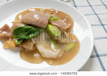 Rad Na Famous Thai Chinese style wide rice noodle dish with tasty tender pork with thick gravy sauce. close up