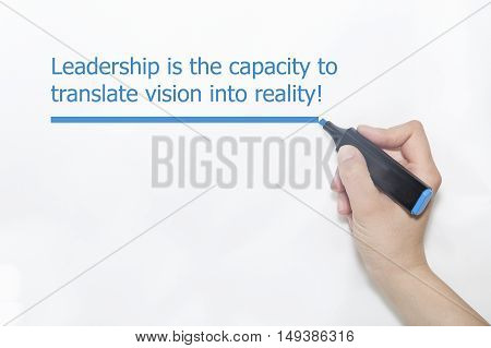 Hand writing "Leadership is the capacity to translate vision into reality" with marker on isolated on white