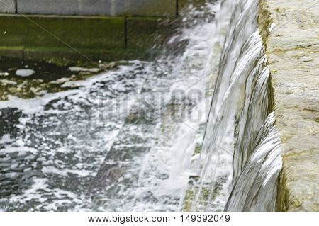 Water cascades down manmade waterfall along Boston's Harborwalk