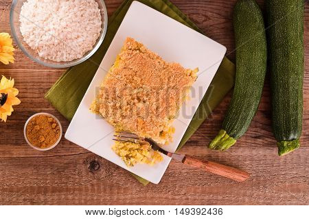Rice timbale with zucchini on wooden table.