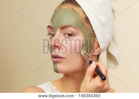 Woman Applying With Brush Clay Mud Mask To Her Face