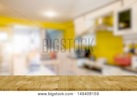 Empty wooden table and kitchen room blur background with bokeh image for product display montage.
