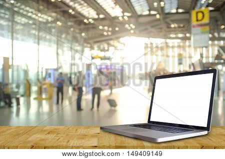 Laptop Showing Blank Screen with Blurred of Check in Counter and Passengers in a airport departure terminal.
