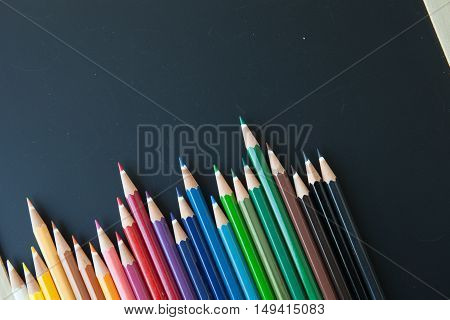 various color pencils on a blackboard background