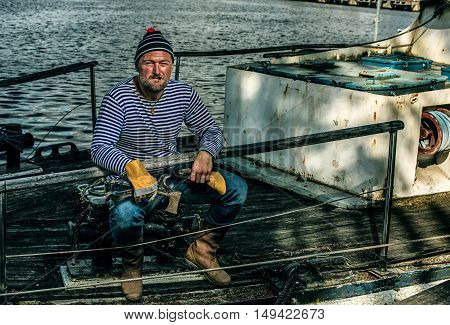 Old salt man smoking on his rusted ship