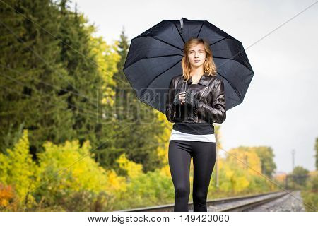 Girl, Umbrella And Rails In Autumn Day