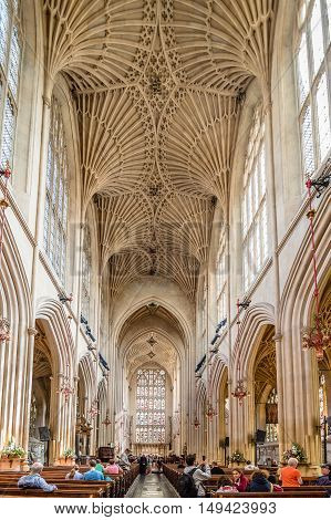 Bath UK - August 15 2015: Interior of Bath Abbey with interior view with faithful praying . The abbey is an Anglican parish church and an active place of worship