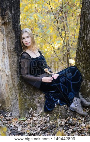 Portrait Of A Young Long-haired Blond Girl In A Black Dress Posing