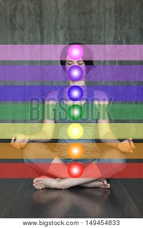 Woman practicing meditation with the chakras. Beautiful young woman doing yoga meditation in lotus posture with the activation of the chakras on the body