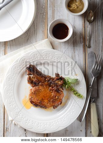 grilled steak on a white plate, sauce and herbs