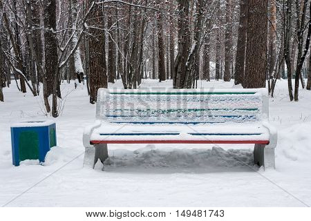A bench in winter park after snowfall. Nobody.