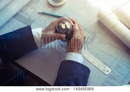 Architects holding coin jar while Discussing Plan in office.