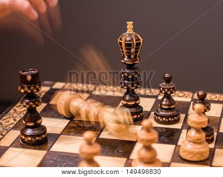 In a lost game of chess, the person playing white gives up the match and throws down the king.