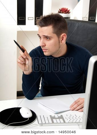 Mladý muž myšlení u počítače