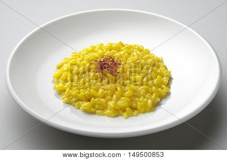 Saffron risotto dish isolated on grey plane