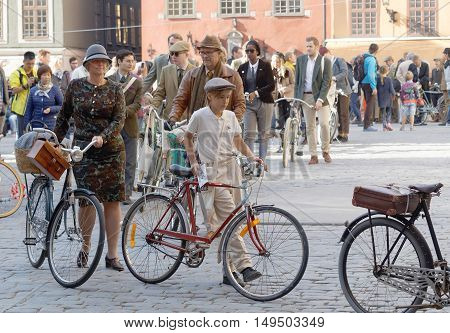 STOCKHOLM - SEPT 24 2016: Many people in old fashioned clothes in a queue leading their bicycles in the Bike in Tweed event September 24 2016 in Stockholm Sweden