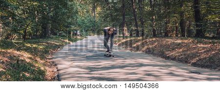 Skateboarder Ride A Longboard Through The Forest – Panorama