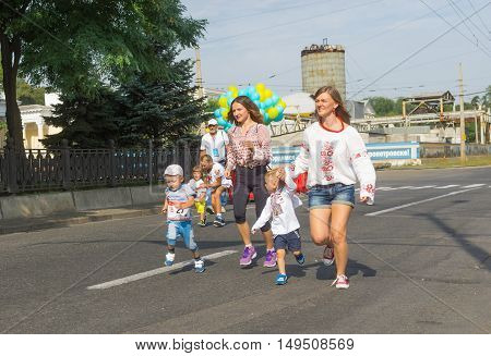 DNEPR, UKRAINE - AUGUST 24, 2016: Kids running with moms in Vyshyvanka Run during Independence Day local activity in Dnepr Ukraine at August 24 2016