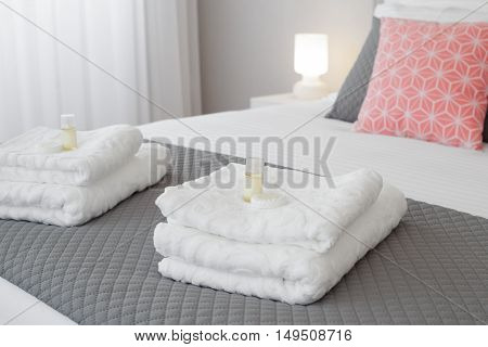 Bed with fresh towels and amenities in a bright room