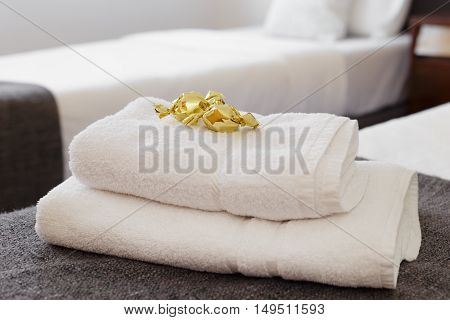 Bed with fresh towels and amenities in bright room