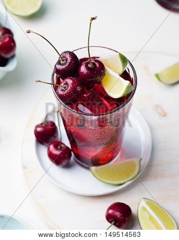Cherry Limeade, lemonade, cola, cocktail in a tall glass on a white, turquoise background Copy space