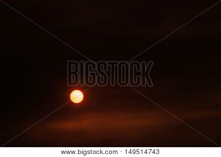 Summer sunset and orange sun over dramatic red clouds