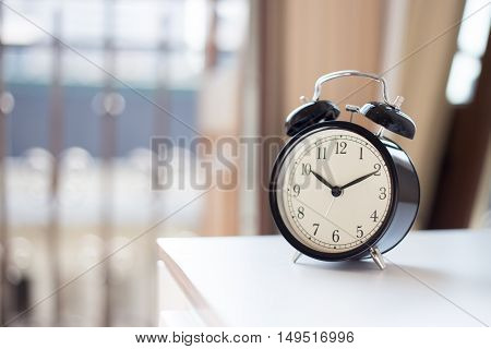 A black alarm clock on the nightstand